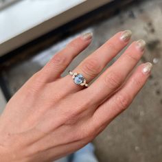 a woman's hand with an engagement ring on her left and the other hand holding it