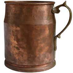 an old copper colored metal mug with handle