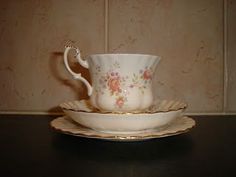 a cup and saucer sitting on top of a black table next to a wall