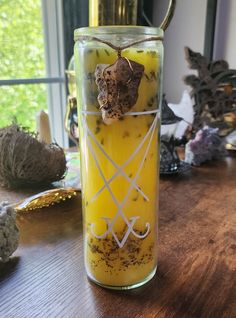 a jar filled with yellow liquid sitting on top of a wooden table