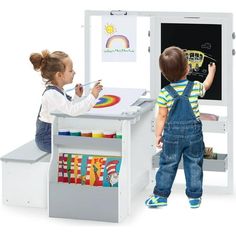 two children are playing with a chalkboard and easel set in the playroom