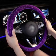 a person is driving a car with purple cloth on the steering wheel and dash board