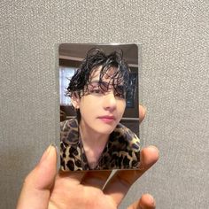 a person holding up a polaroid with a photo of a woman in leopard print