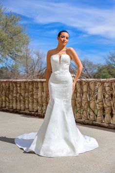 a woman in a wedding dress posing for the camera