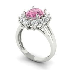 a pink diamond ring with white diamonds on the sides and an oval center stone in the middle