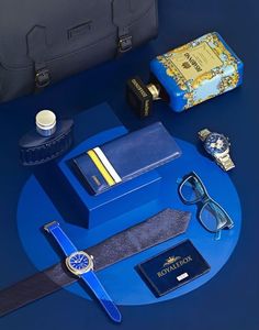 a blue table topped with lots of items like a watch, wallet and other items