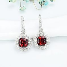 Features These Cushion Ruby Halo Sterling Silver Drop Earrings feature a classic and stylish design style suitable for any occasion.Made all by hand! It truly deserves a spot in every jewelry collection. Beautifully crafted, this style is sure to become a treasured keepsake. Each Ruby used for our jewelry was carefully checked and verified by our experts, so that they meet the highest standard. Providing high-quality items is our most important goal, which starts with selecting the best stones a Fine Jewelry Halo Design Drop Earrings, Halo Drop Earrings For Anniversary, Classic Drop Earrings With Halo Design, Classic Halo Design Drop Earrings, Formal Halo Drop Earrings, Halo Diamond Drop Earrings As Gift, Halo Dangle Earrings For Anniversary, Halo Design Bridal Drop Earrings For Gift, Classic Halo Drop Earrings