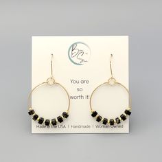 These gold hoops, adorned with black jasper beads, add a touch of eclectic elegance to any outfit. Perfect for any boho babe, these earrings are a must-have for your collection. 14k Gold Filled Wire Measure approximately 1.125" in diameter Earrings Hang 1.75" from top of ear wire Black Jasper Gemstones Polished to a high shine Sent in a Gift Box with Polishing Cloth Handmade in Montana Eclectic Elegance, Black Jasper, African Turquoise, Jasper Beads, Jasper Gemstone, Gold Hoops, Jewelry Packaging, Ear Wire, Christmas Shopping