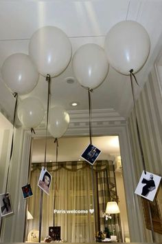 some white balloons hanging from the ceiling in a room