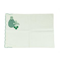 a green and white dish towel with an embroidered fruit design on the front, sitting on a white surface