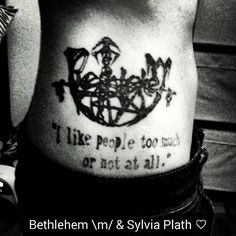 a black and white photo of a man's back with tattoos on his stomach