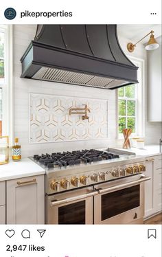 a stove top oven sitting inside of a kitchen next to white cabinets and counter tops