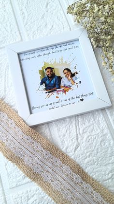 a white frame with a couple's photo on it next to some twine