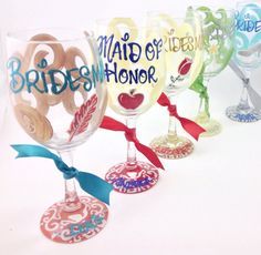 there are many wine glasses that have different designs on the glass and ribbons tied around them