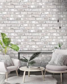 two chairs and a coffee table in front of a brick wall with potted plants