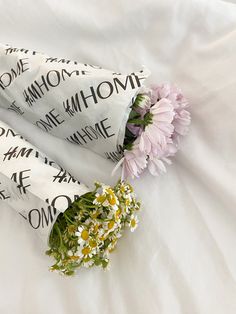 flowers are laying on the white sheet with words written all over it and one flower is in between them