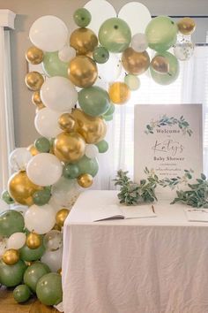 a table topped with balloons and greenery