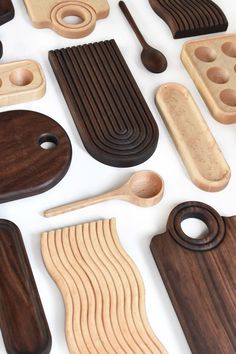 wooden spoons and other kitchen utensils laid out on a white surface