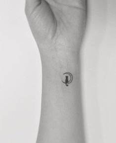 a woman's wrist with a small bird tattoo on the left side of her arm