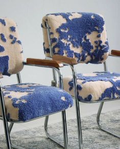 two chairs with blue and white patterned upholstered backrests on carpeted area