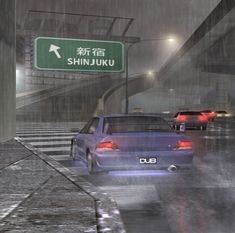 several cars driving down a wet street in the rain at shinjuuku station