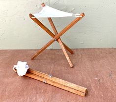 a small wooden stand with a white cloth on it and a piece of wood sticking out of the floor