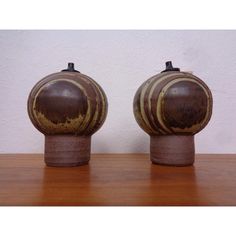 two brown vases sitting on top of a wooden table