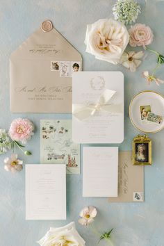 the wedding stationery is laid out with flowers