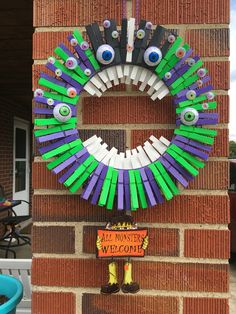 a wreath made out of toothpicks and fake eyes on the side of a brick building