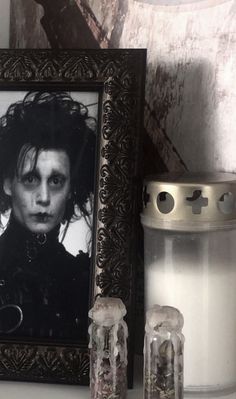 there is a framed photo next to two candles