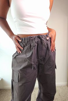 Introducing Too Cool Parachute Cargo Pants. These stylish charcoal gray pants feature a wide leg design and convenient side pockets. Stay on-trend while having all your essentials at hand. Elevate your wardrobe with these comfortable and functional pants. Sizing Salena is a size 4 wearing the small and 5’6 If between sizes we recommend sizing down! Small: 2-4 Medium: 6-8 Large: 10-12 Everyday Wide-leg Parachute Pants With Cargo Pockets, Summer Cargo Pocket Ankle-length Parachute Pants, Solid Full-length Parachute Pants With Cargo Pockets, Gray Wide-leg Parachute Pants With Cargo Pockets, Ankle-length Cargo Pants With Elastic Waistband, Grey Pants, British Indian, Charcoal Grey, Cargo Pants