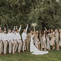 a group of people standing next to each other on top of a lush green field