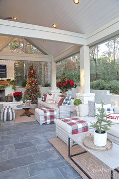 a covered patio with couches and christmas trees