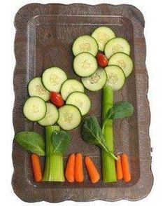 there are cucumbers, carrots and celery arranged on a tray