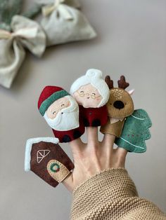 a person holding several small stuffed animals in their hands with santa and reindeer on them