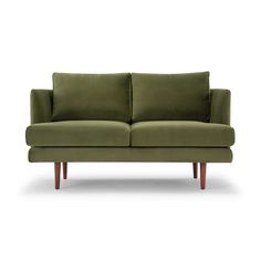 a green couch sitting on top of a white floor