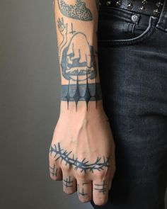 a man with tattoos on his arm and hand