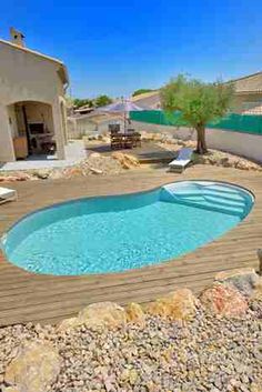 an empty swimming pool surrounded by rocks and stones