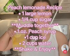 a woman holding a drink in front of her face with the words peach lemonade recipe