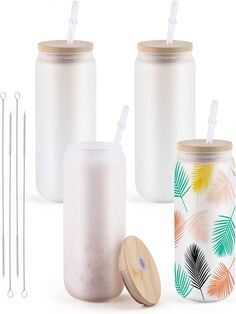 three plastic jars with straws and two drinking glasses next to each other on a white background