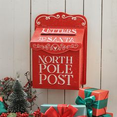 a red mailbox sitting next to christmas presents