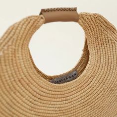 Grass woven bag in a pleasing round shape and finished with the finest Italian leather handle. 12x12x3 inches. Protective dust bag included. Elegant Straw Bag With Round Handle In Natural Color, Modern Handwoven Natural Straw Bag, Modern Straw Bag With Round Handle, Elegant Straw Bag With Round Handle For Daily Use, Luxury Natural Shoulder Bag With Rolled Handles, Luxury Straw Bag With Braided Round Handles, Chic Natural Straw Bag With Round Handle, Chic Hobo Bag With Braided Handles, Elegant Natural Bucket Bag With Round Handle