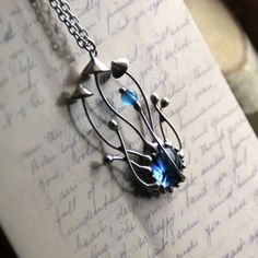 a close up of a necklace on a piece of paper with writing in the background