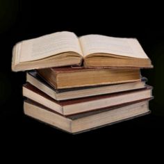 a stack of books sitting on top of each other in front of a black background