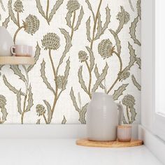 a white shelf with two vases on top of it next to a wall paper