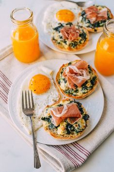 eggs, ham and spinach on toast with orange juice in glass jars next to them