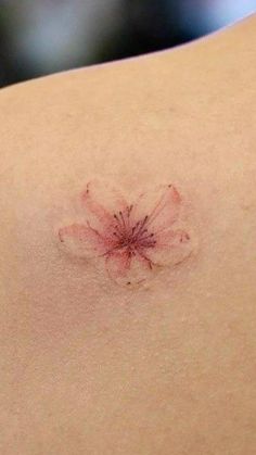 a small flower on the back of a woman's shoulder