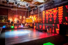 an empty stage set up for a party with neon lights and decorations on the walls