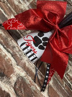 a red bow with black and white designs on it is attached to a brick wall