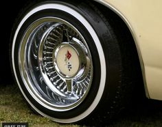 the front wheel of a classic car with chrome rims